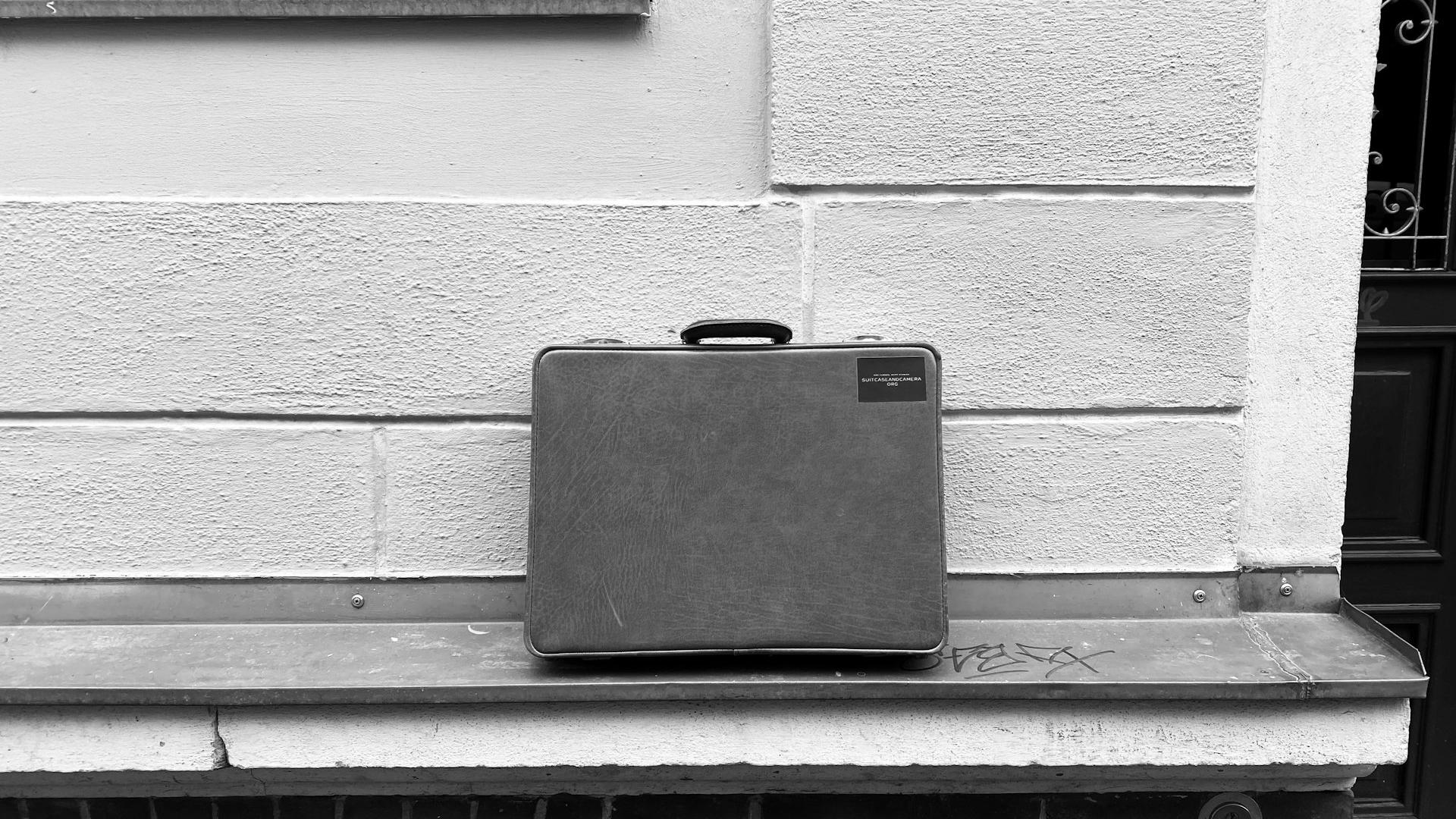 a suitcase sitting on a bench in front of a building